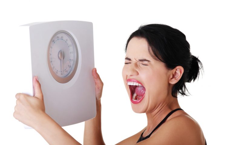 Frustrated woman with scale