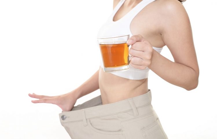 woman holding a drink ad showing that she lost inches off her waist