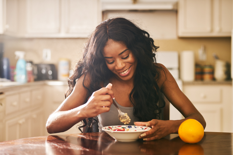 girl smiling and eating her oatmeal